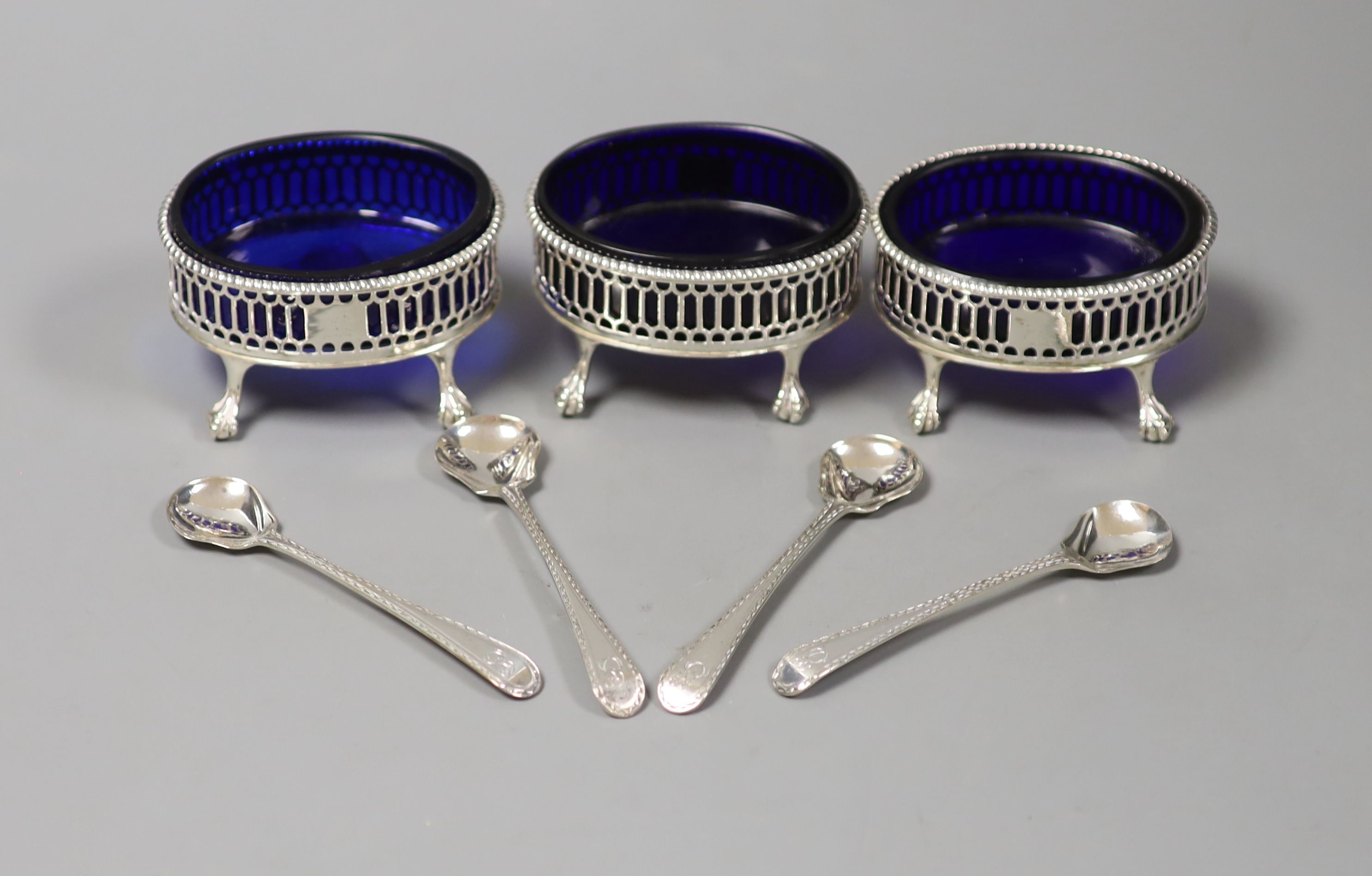 A set of three George III oval pierced silver salts, D & R Hennell, London 1771, 81mm and four bright cut spoons.